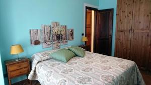 a bedroom with a bed and a blue wall at Holiday House Montepulciano - Il Torrino in Montepulciano