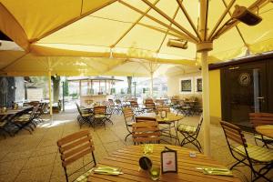 an empty restaurant with tables and chairs and umbrellas at Schüdlbauer´s Hotel-Restaurant-Bar in Braunau am Inn