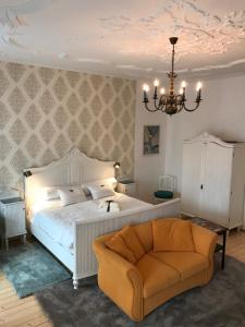 a bedroom with a bed and a chair and a chandelier at Lovely Flat in a Lovely City in Steyr