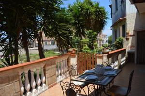 a table and chairs on a balcony with palm trees at Casa Seva in Tropea