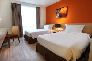a hotel room with two beds and a window at SGI Vacation Club Hotel in Melaka