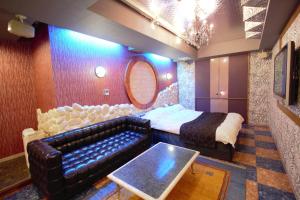 Hotel LaLa (Adult Only) في ساكاي: غرفة نوم مع أريكة وسرير وطاولة