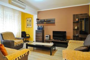 a living room with two chairs and a flat screen tv at Apartment S&T in Tivat