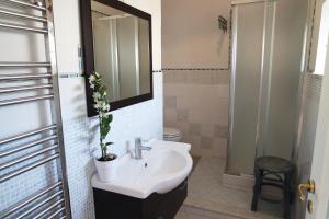 łazienka z umywalką, toaletą i lustrem w obiekcie Eleatica Holiday Apartment w mieście Ascea
