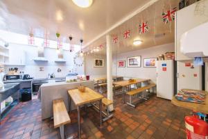 eine Küche mit Tischen und einem Kühlschrank im Zimmer in der Unterkunft Astor Museum Hostel in London