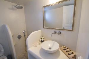 a bathroom with a white sink and a mirror at Evilio Houses in Oia