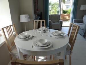 a white dining room table with chairs and a white table and chairsktop at Ula Cottage in Saint Helens