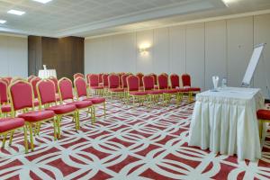 a conference room with red chairs and a table with a podium at Demircioğlu Park Hotel in Muğla
