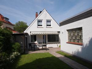 ein weißes Haus mit einem Tisch im Hof in der Unterkunft Döser Hus in Cuxhaven