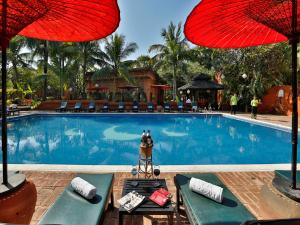 a swimming pool with two chairs and two umbrellas at Amazing Bagan Resort in Bagan