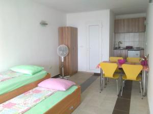 a room with two beds and a table and chairs at Apartmani Lav in Sutomore