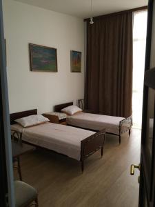 two beds in a room with a window at Art Guesthouse in Yerevan
