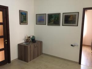 a room with three pictures on the wall and a wooden cabinet at Art Guesthouse in Yerevan