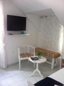a living room with a chair and a tv on the wall at Apartment Josip in Korčula