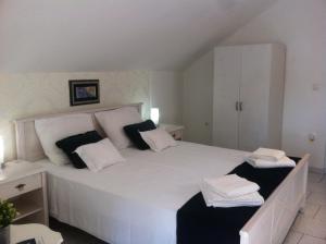 um quarto com uma cama branca com almofadas pretas e brancas em Apartment Josip em Korčula