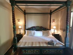 a bedroom with a canopy bed with two lamps at Santai guesthouse in Brits