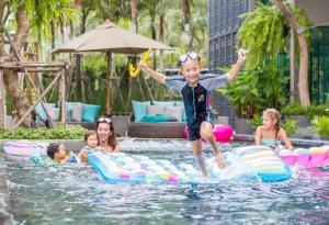 a young child jumping into the water in a pool at AtEase Phuket Patong in Patong Beach