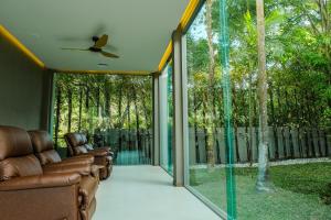 a screened in porch with a couch and a ceiling fan at AtEase Phuket Patong in Patong Beach