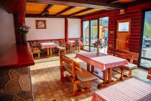a restaurant with a table and benches and tables and chairs at Guesthouse Madzarevic in Plužine
