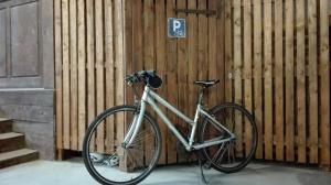 uma bicicleta estacionada em frente a uma parede de madeira em Beaune Hôtel em Beaune