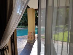 a view of a pool through a glass door at Santai guesthouse in Brits