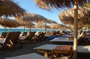 エギオにあるSpiti Ostriaの浜辺の椅子・藁傘