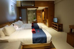 ein Hotelzimmer mit zwei Betten und einem Fernseher in der Unterkunft Koh Ma Beach Resort - SHA Extra Plus in Mae Haad + 37 Fotos