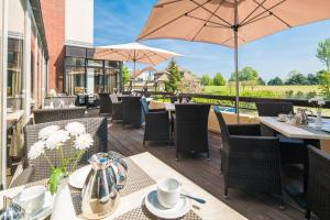 an outdoor patio with tables and chairs and umbrellas at Villa am Meer in Grömitz