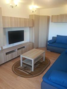 a living room with a couch and a table and a tv at Apartament Rega Mrzeżyno in Mrzeżyno