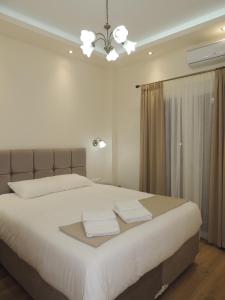 - une chambre avec un grand lit blanc et un lustre dans l'établissement Apartment near Acropolis, à Athènes
