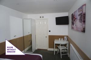 a room with a bed and a table with a chair at Accommodation London Bridge in London