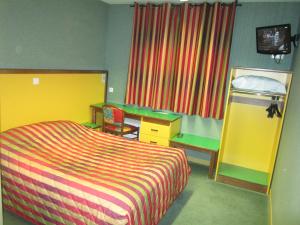 1 dormitorio con cama, escritorio y espejo en Hotel Siatel Metz en Norroy-le-Veneur