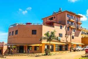MbaleにあるMbale Travellers Innのヤシの木が前に生えている高い建物