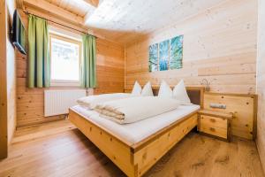 1 dormitorio con 1 cama en una cabaña de madera en Ferienwohnungen Schwabhof, en Kleinarl