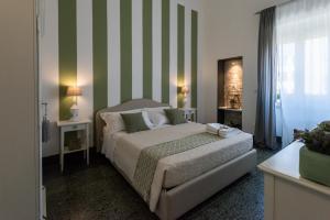 um quarto com uma cama com listras verdes e brancas em Palazzo Bignami em Lecce