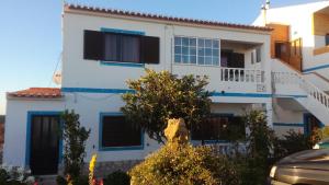 a white house with blue trim at Casa Oceano in Praia da Arrifana