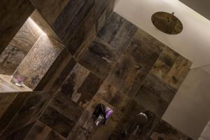 a bathroom with a shower with wooden tiles at Apartament Parkowy in Nałęczów +19 photos