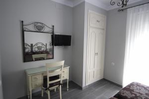 a bedroom with a desk and a mirror on the wall at Hostal Roma in Seville