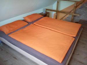 グラール・ミューリッツにあるHaus Sonnenscheinのベッド(オレンジのシーツ、オレンジの枕付)