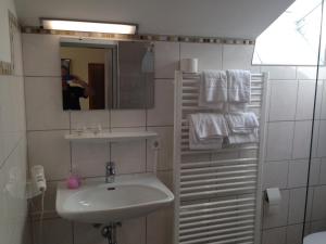 a white bathroom with a sink and a mirror at Hotel Sonnenhof in Thannhausen