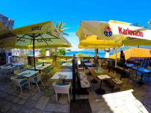 un ristorante con tavoli, sedie e ombrelloni di Accommodation Old Town Vitaic a Korčula