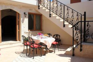 a table and chairs on a patio with a staircase at Ioanna House in Gonia