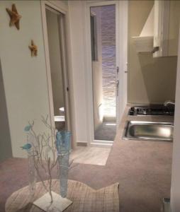 a kitchen with a sink and a vase with a tree in it at Dimore di Mare in San Pietro Vernotico