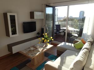 a living room with a couch and a table and a tv at Apartament dla Ciebie z tarasem i garazem in Kołobrzeg