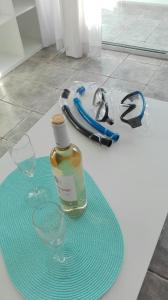 a bottle of alcohol and two glasses on a table at Pino's Vivienda Vacacional in Costa Del Silencio