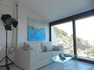 ein Wohnzimmer mit einem weißen Sofa und einem Glastisch in der Unterkunft Cap sa Sal Lofts in Begur