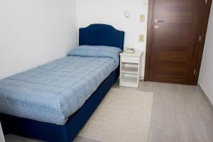 a bedroom with a blue bed and a night stand at Hotel Cristallo in Riolo Terme