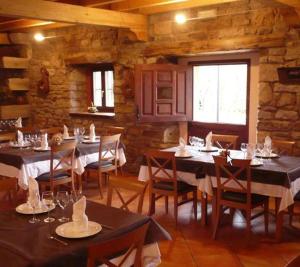 una sala da pranzo con tavoli e sedie in un ristorante di Posada Molino La Vega a Reinosilla