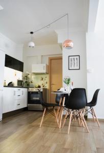 テッサロニキにあるStay Apartment by Skg Apartmentsのキッチン、ダイニングルーム(黒い椅子、テーブル付)