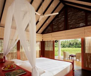 a bedroom with a bed with a mosquito net at Jetwing Kaduruketha in Wellawaya